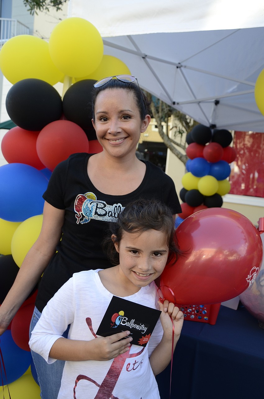 Liz Hane and her daughter, Skye, 9, work the Balloonistry booth.