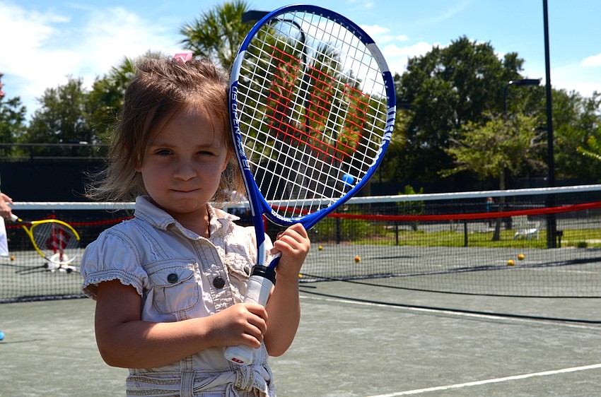 Three-year-old Avery Volk participates in the tennis festivities with her friends and sister.