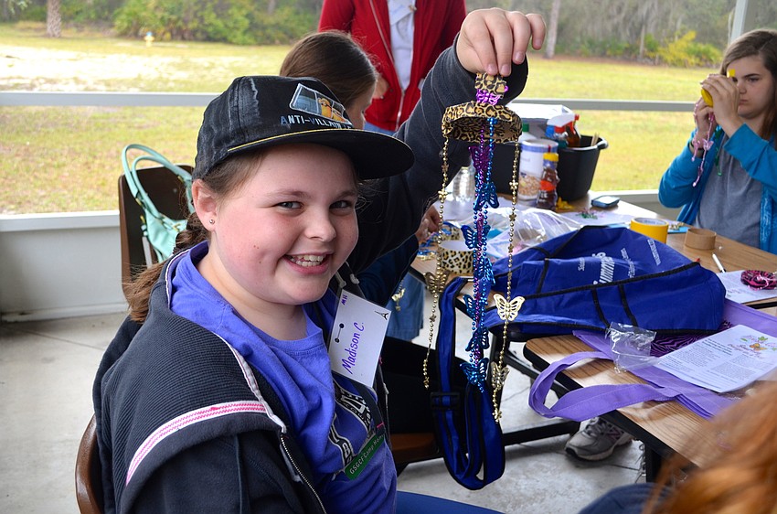 Middle school student Madi Campbell shows off the wind chime she crafted.
