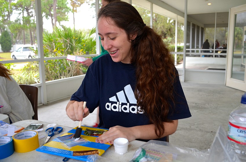 Fifteen-year-old Katie Marchetti crafts  a board for a utopian-themed project.