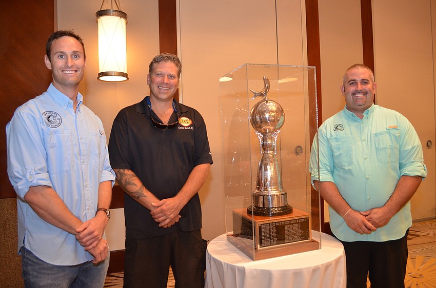 Tournament Chairman Mason Tush, with Travis Lofland from the show “Deadliest Catch” and tournament committee member Bryan Wells pose with the trophy.