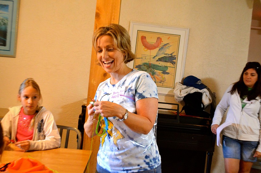 Becky Morris, of Sarasota Academy Prep, leads the girls in making bracelets.