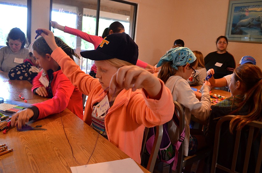 Sydney Payne, 10, measures the length of her bracelet.