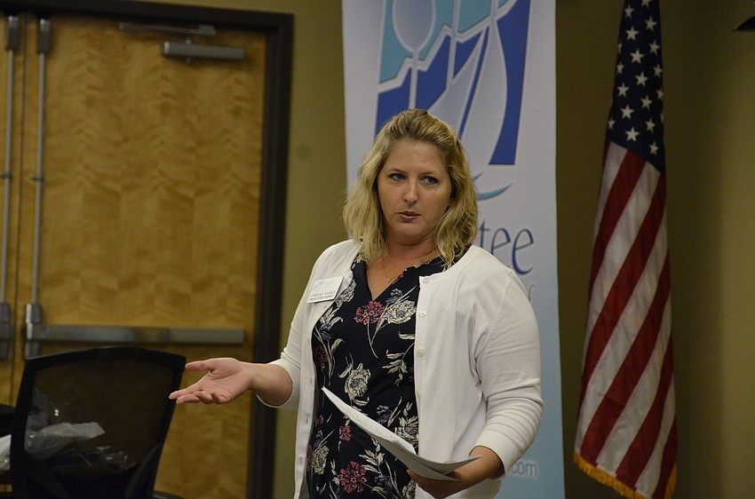 Kimberly Kramer with the Manatee Chamber of Commerce alerts luncheon attendees to upcoming events.