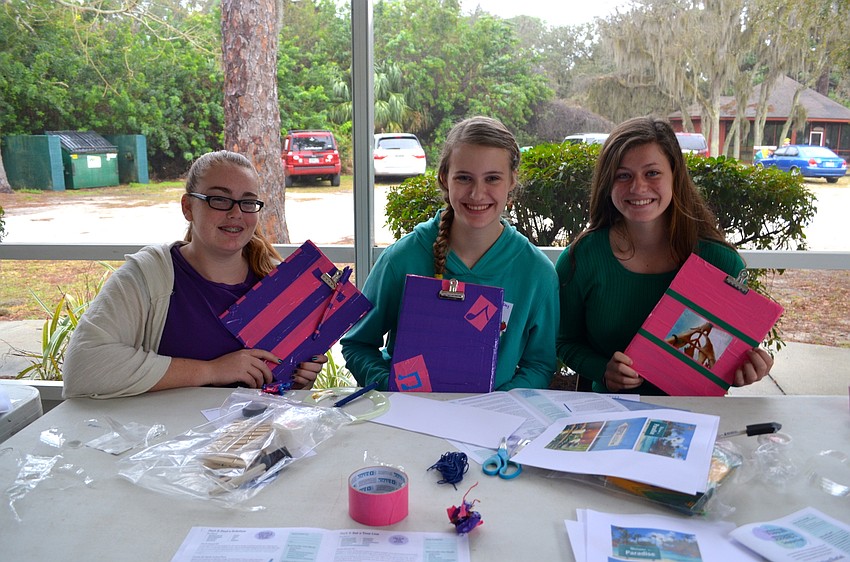 Grace Townsend, Cypress Potter and Maddie Bricker decorate bright boards they will use for a project later.