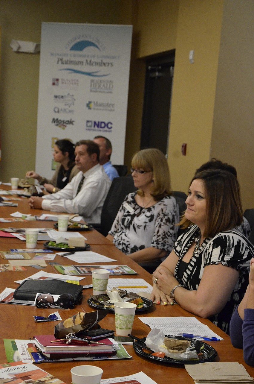 Business representatives listen to each other describe their target clients.