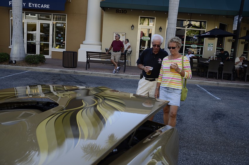 Tom and Betty South admire a 2008 Corvette with an eagle detail on the hood.
