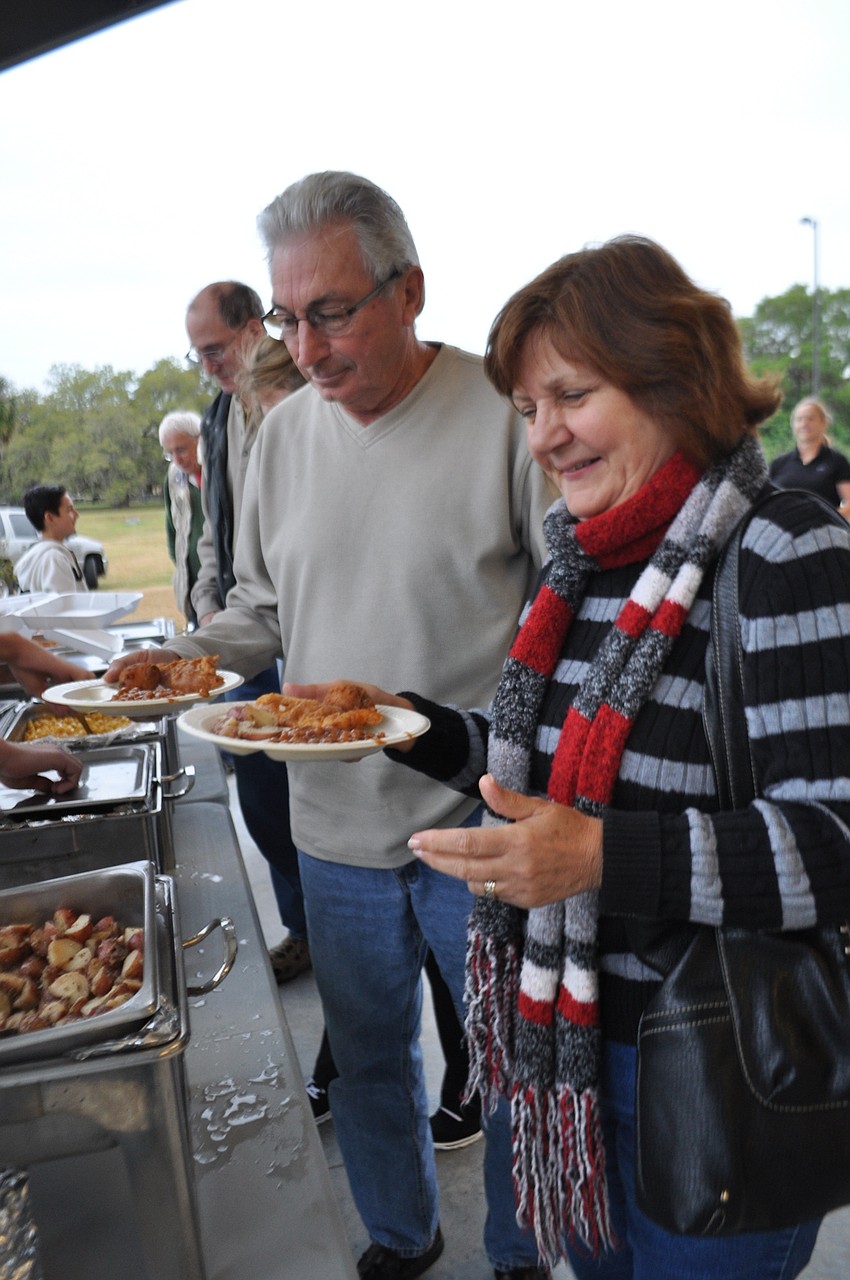 Anne Farrer, front, fills up her plate.