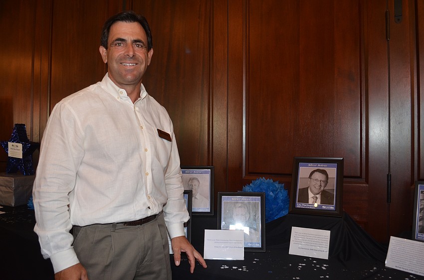 Alliance Chairman David Fink shows off the a table honoring the Alliance's former chairmen and women.