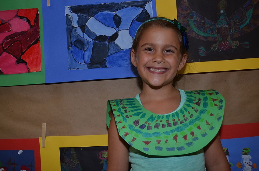 Six-year-old Isabella Andraed shows off her Egyptian-style paper necklace.