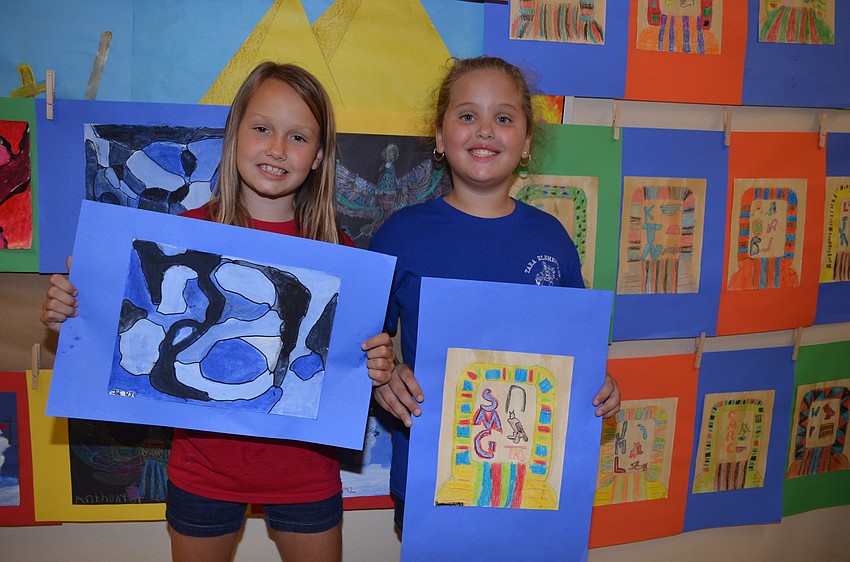 Friends Joli McElroy and Savannah Getman showcase their painting along with 598 others at the school's art show.