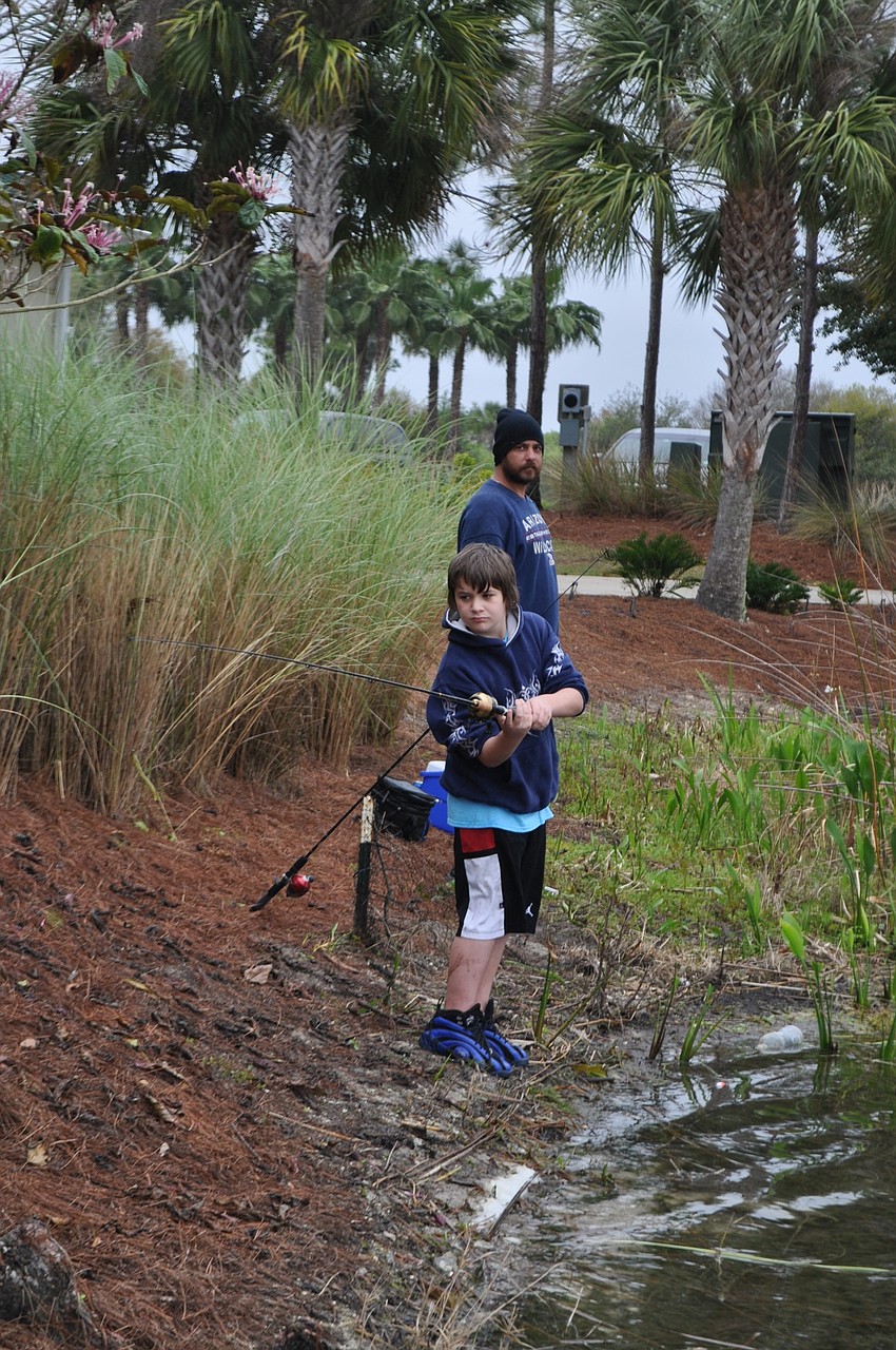 Demitry Routledge, 11, fishes with his dad, Ryan Stilwell.