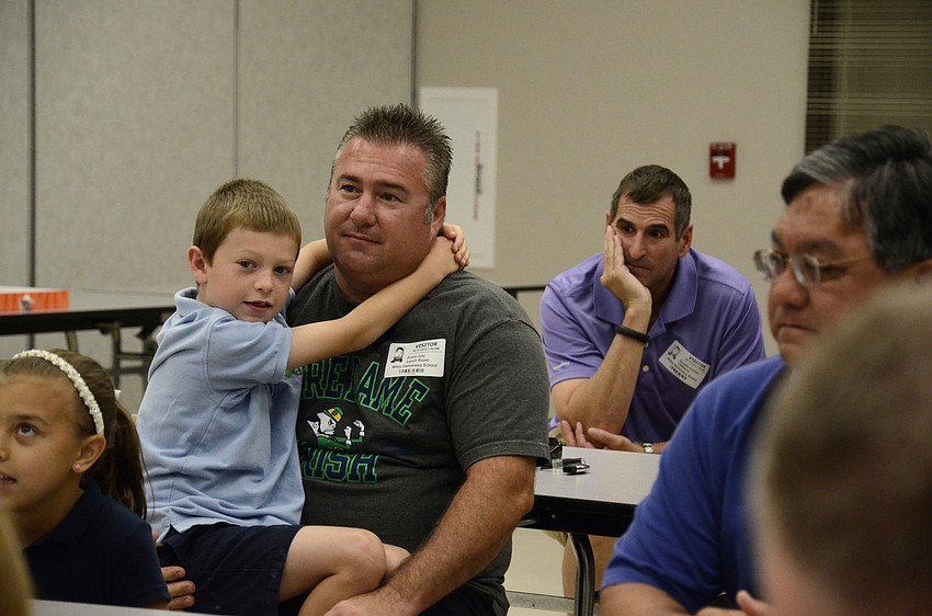 Kindergartener Peyton Gray and his dad, Duane, listen to other students say why their dad is cool.