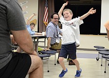 Peyton Gray, a kindergartener, dances back to his seat after winning the All-Pro Dad Breakfast raffle for a t-shirt.