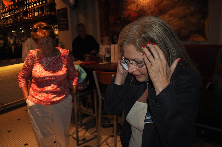 Liz Alpert receives a call for the poll results.
