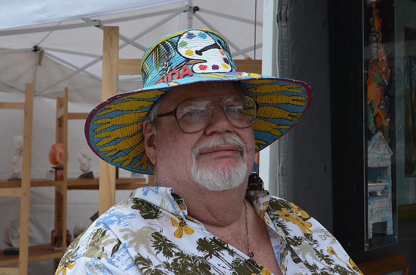 Bill Darrah with his artwork and hand-painted hat.