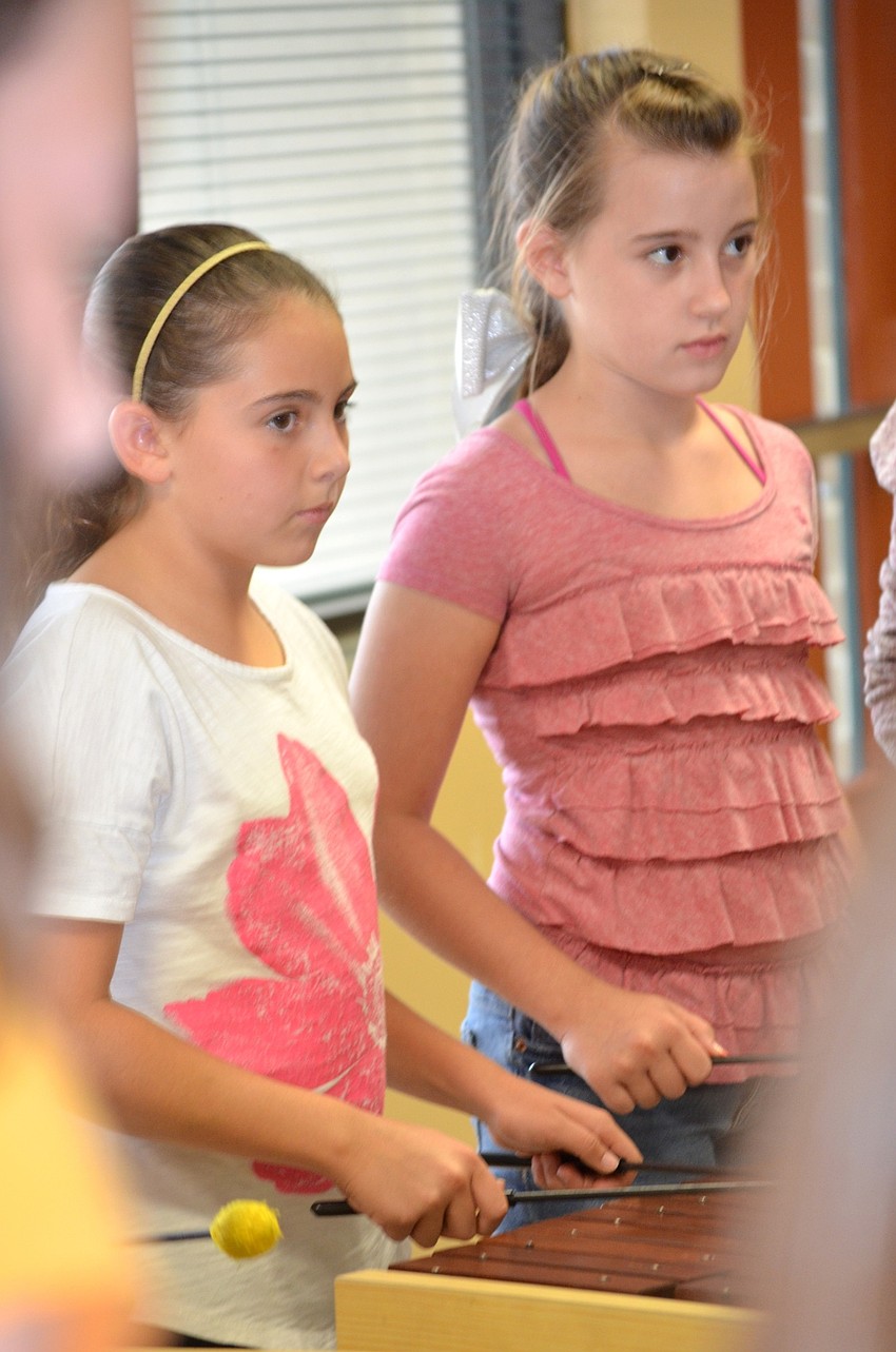 Ava Barak and Amber Parsons create their own music, while following they teacher's lead.