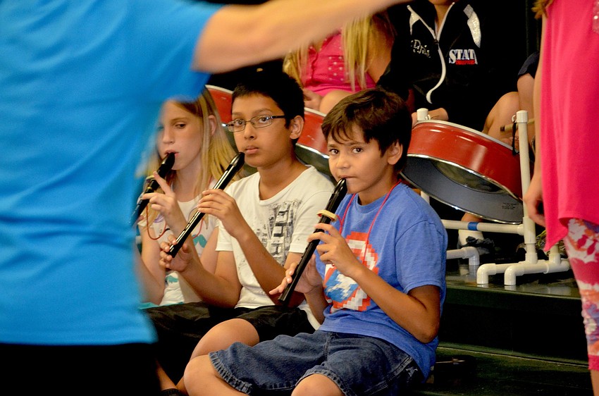 Nora Seacord, Jonathan Xavioer and Colton Korney play recorders to the beat.
