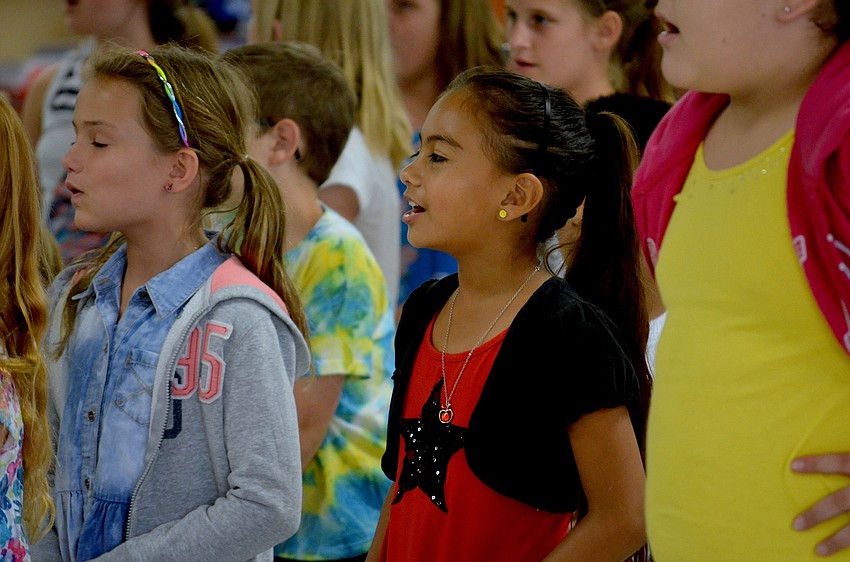 Second-grade student Evelyn Ortega sings along to the Witt Elementary school song.