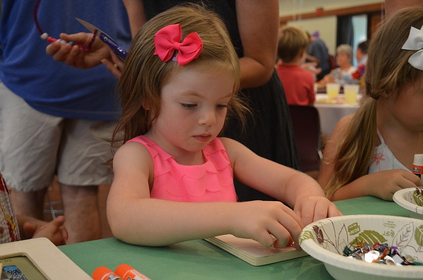 Parker Barsello adds gems to her picture frame.