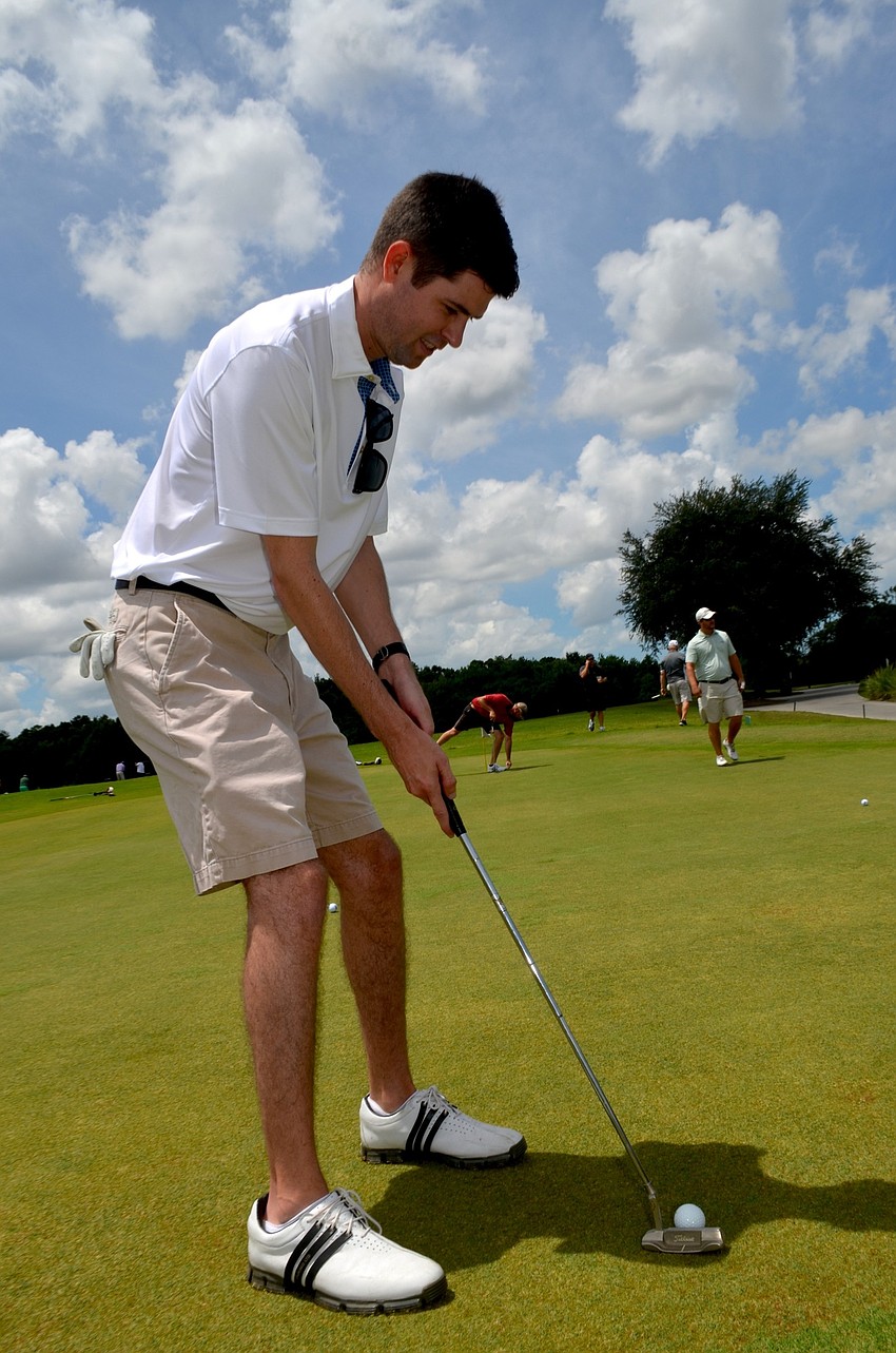 Austin Boyd focuses on the ball while putting.