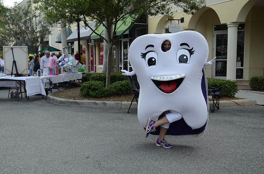 Carrie Betts, aka Supertooth, dances in the street while representing Monricz and Varone Orthodontics.
