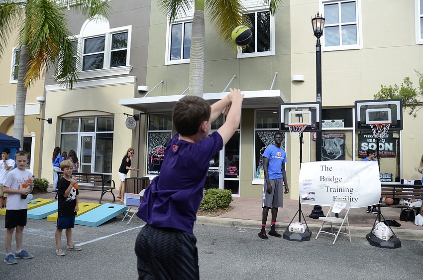 Lucas Hall, a sixth-grade student, attempts to make a basket at the Florida Sons Bridge Training Facility booth.
