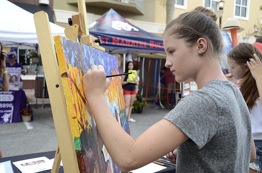 Sarah Eckstrom, seventh-grade student, dabs a few last brush strokes of blue on her colorful painting.