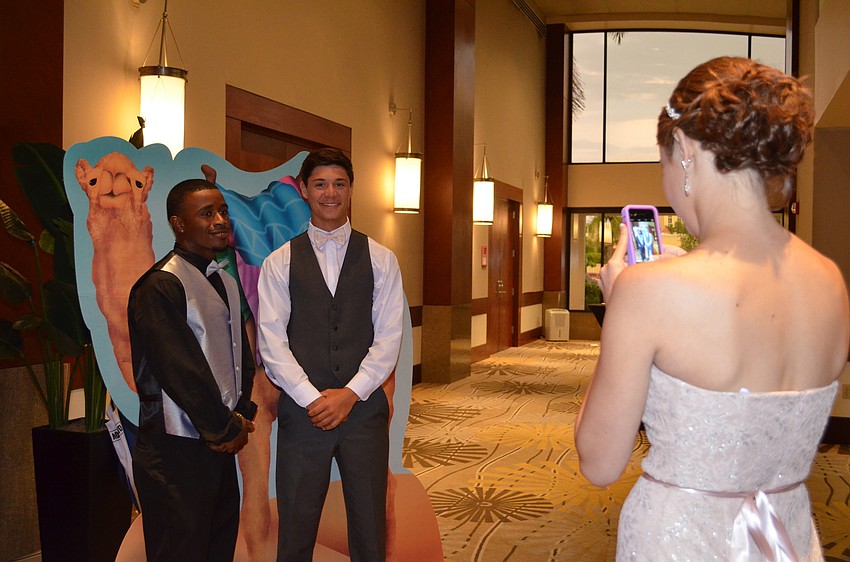 Justin Austin and Erik Bouck pose for a photo with a cardboard cutout of a camel for Emily Coblentz