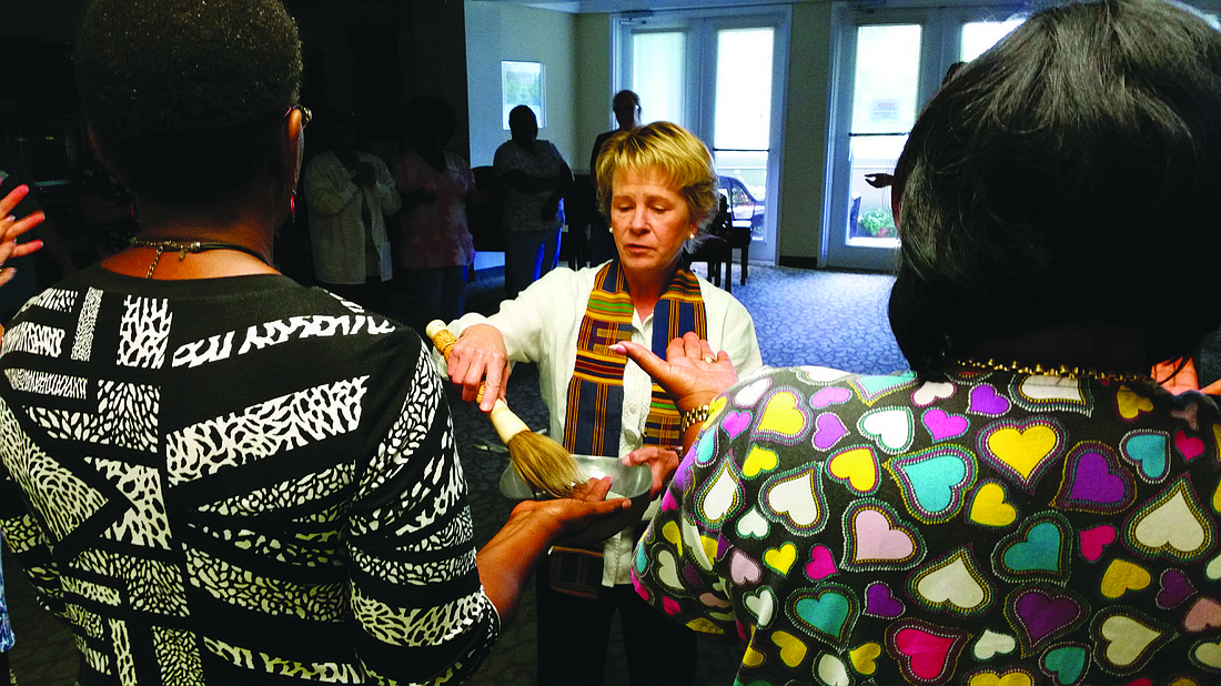Courtesy photo Chaplain Carol Fields blesses the hands of Plymouth Harbor residents and staff Friday.