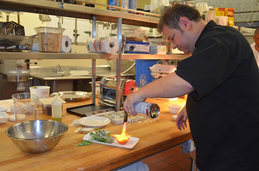 Executive Chef Andrea Bozzolo blow torches the appetizer in order to caramelize the peach.