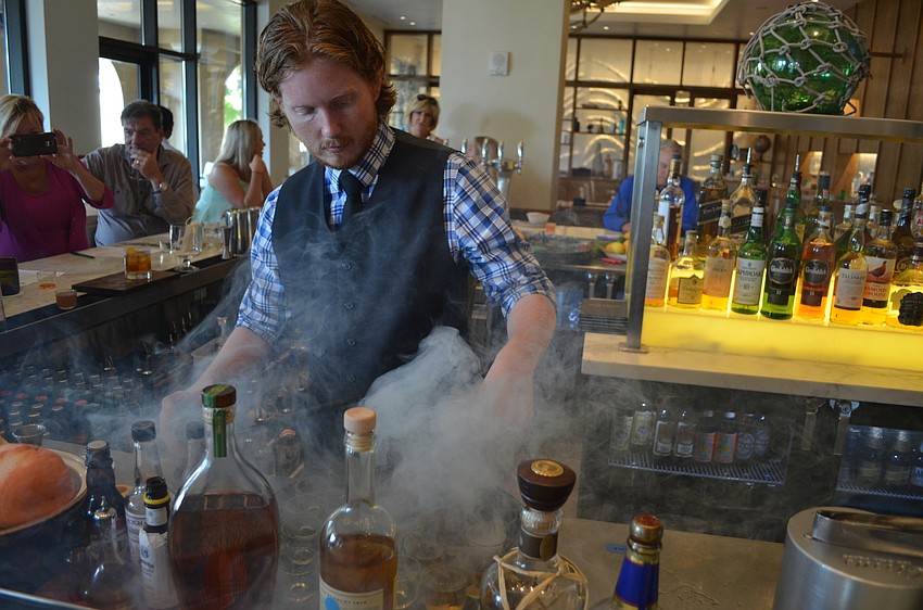 Ingi Sigurdsson adding the smoke from a bourbon barrel over the samples of Over the Barrel