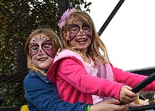 Cousins Abigail Tallent and Maddie Harrison test out a John Deere tractor.