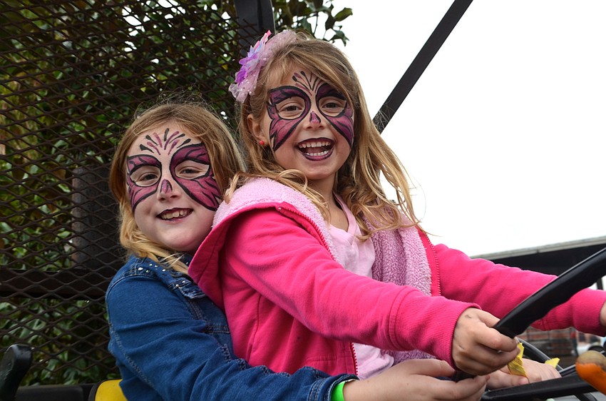 Cousins Abigail Tallent and Maddie Harrison test out a John Deere tractor.