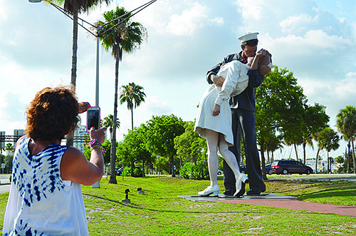 Sue Jones, an Ohio resident who is vacationing in Sarasota, snaps a picture of Unconditional Surrender Wednesday morning. Photo by Amanda Morales