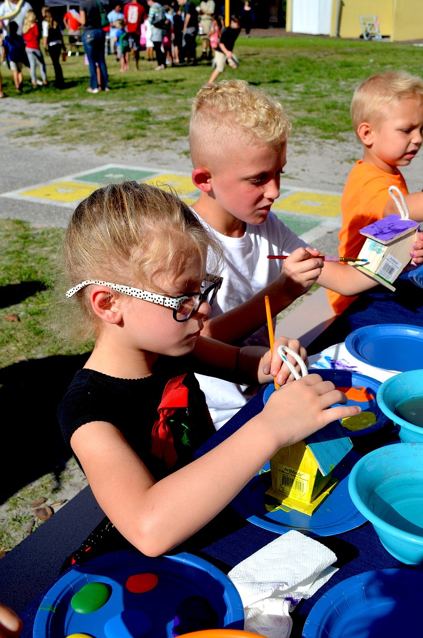 Laylah Camus and her brother, Landyn, decorate a miniature house with paint.