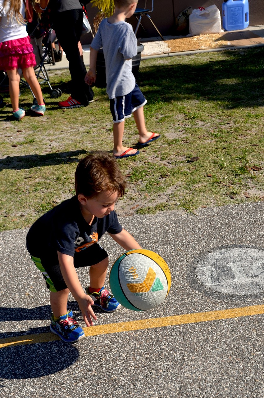 Johnny Gina makes his own fun as he plays with a basketball.