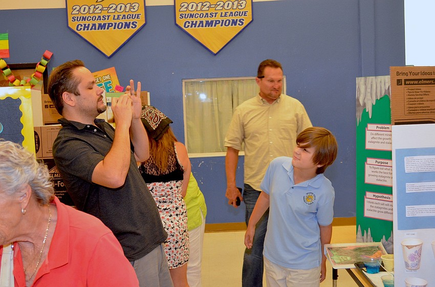 Marc Lalosh snaps a photo of his son, Bryce, and his science project.