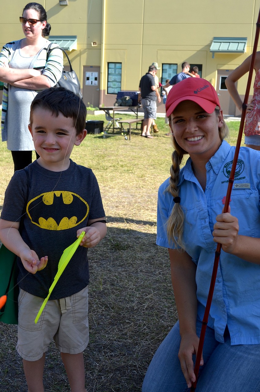 Brodie Stadler learns to fish from Manatee County Natural Resources employee Sierra Lauck.