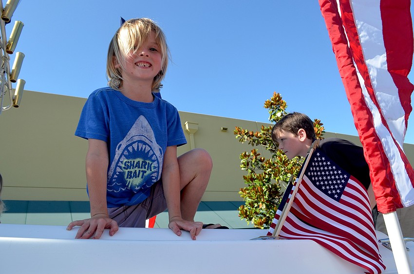 Six-year-old Blair war field climbs onto a boat manned by members of the U.S. Coast Guard.