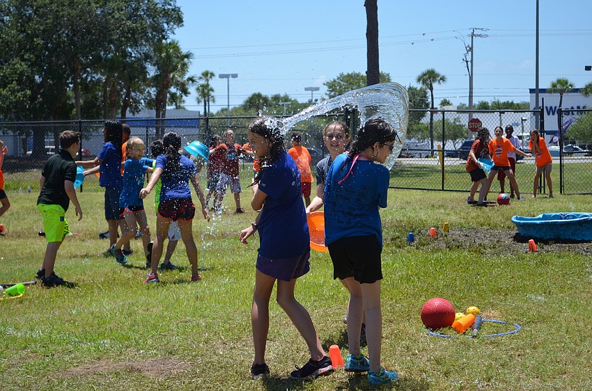 Isabella Emmett splashes team mates  Juliette Davison and Rylie O’Fallon during Field Day at Phillippi Shores Elementary School.