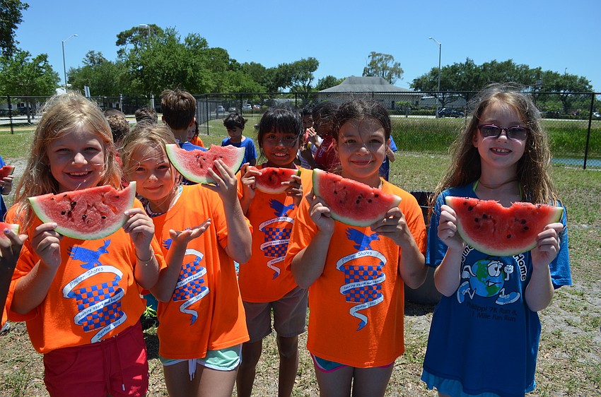 Lenia Unde, Collier Moser, Irandy Ramos, Ghita DiNota and Ava Larson enjoy a slice of watermelon at one of the Field Day stations.