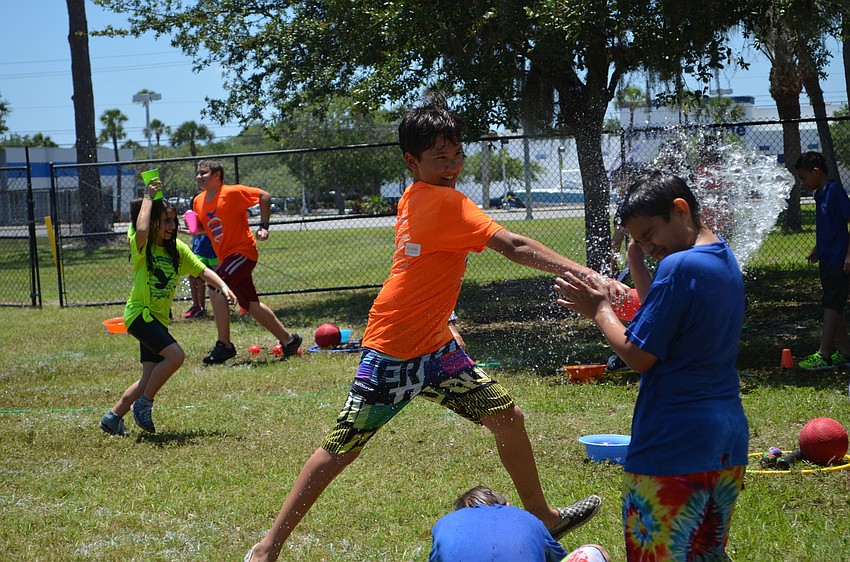 Tsultrim Smith splashes his classmate with water during one of the stations at the Phillippi Shores Elementary School Field Day.