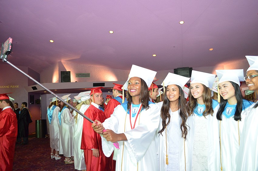 Aude Monde uses a selfie stick to capture memories with classmates.