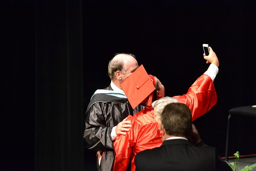 A student stops to take a selfie with Principal Stephen Christie.