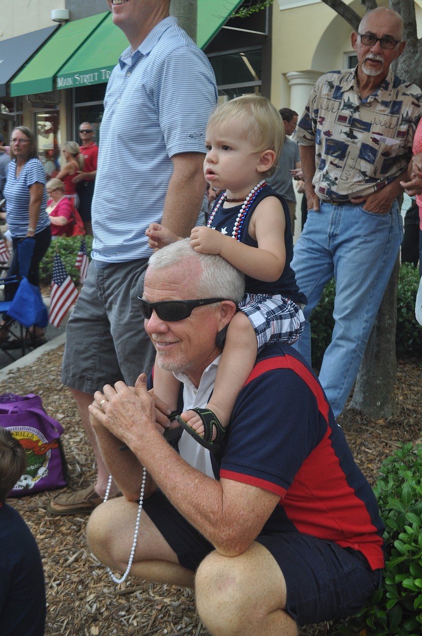 Parker Rhodes, a year and a half old, gets a prime viewing spot on grandfather Martin Medley's shoulder.