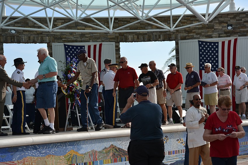 Veterans line up on stage to receive a pin in recognition of their service during the Vietnam War.