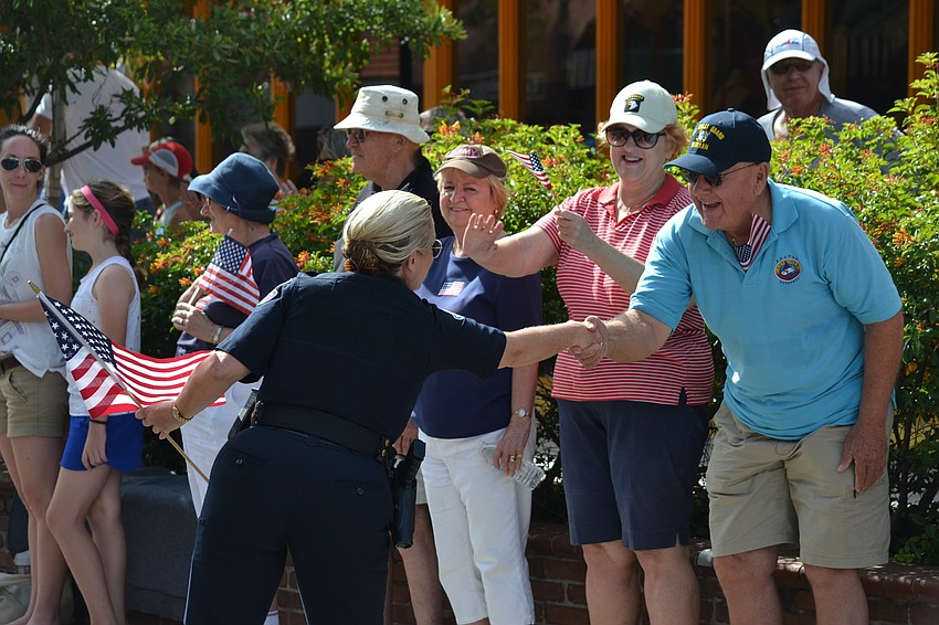 Sarasota Police Department Chief of Police Bernadette DiPino stops on the parade route to recognize veteran Dan Reskow for his service.