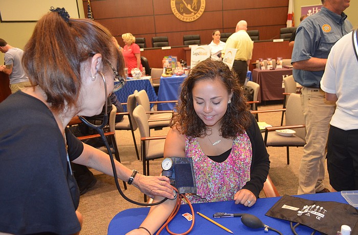 Diane Proios checks Town Planner Maika Arnoldâ€™s blood pressure at the Longboat Key health fair May 21. Photo by Kristen Herhold