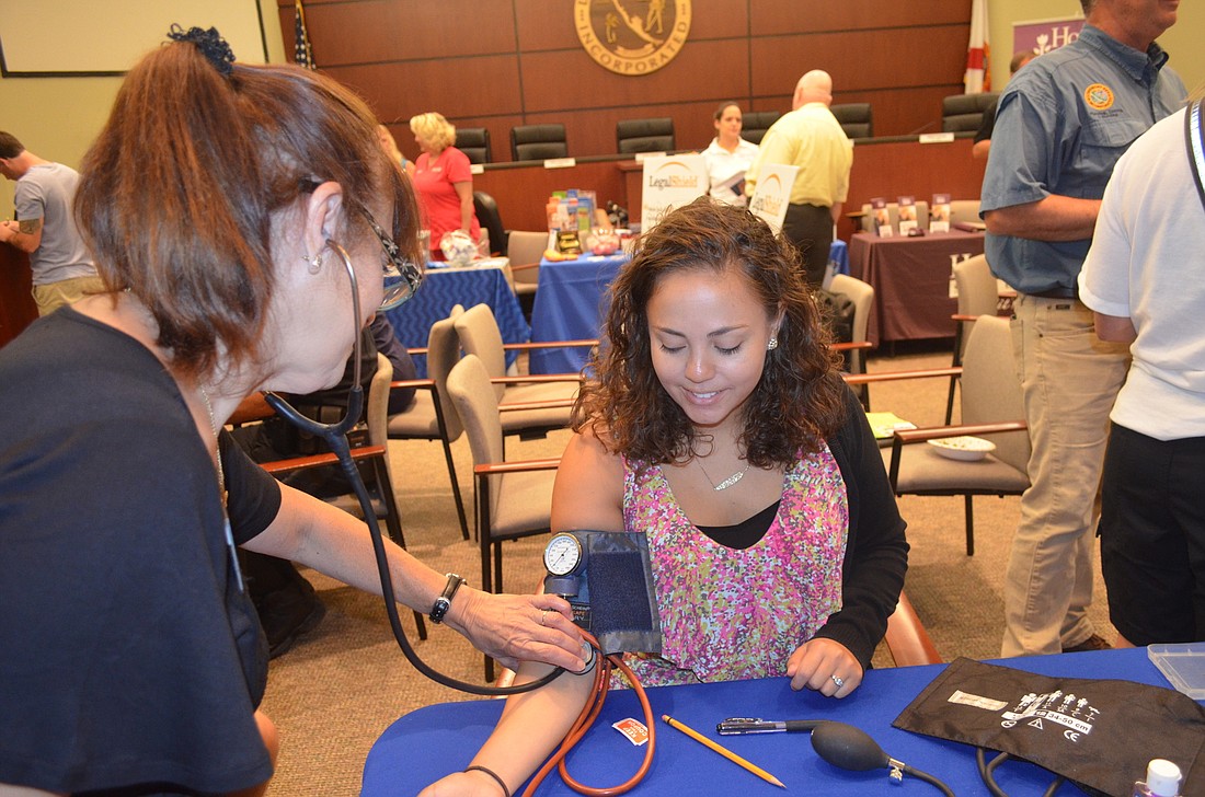 Diane Proios checks Town Planner Maika Arnoldâ€™s blood pressure at the Longboat Key health fair May 21. Photo by Kristen Herhold